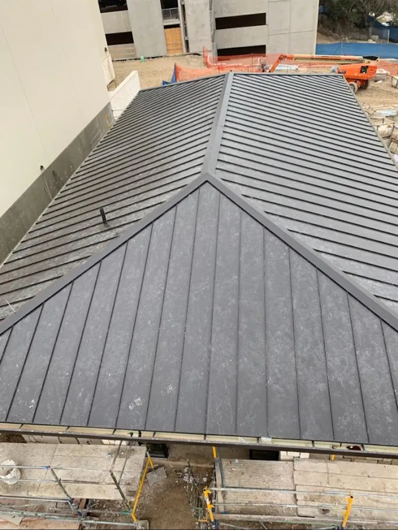 Commercial metal roof construction with crane equipment in Egg Harbor